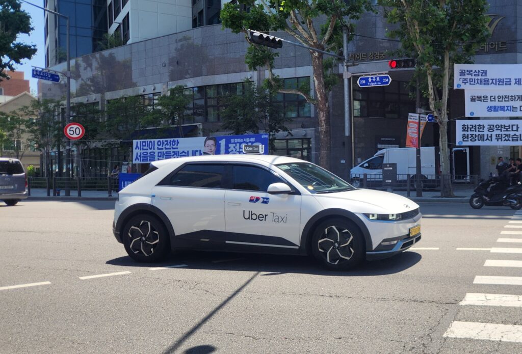 An official Seoul taxi with the Uber logo on the street, featured in a 2026 Korea Taxi Guide